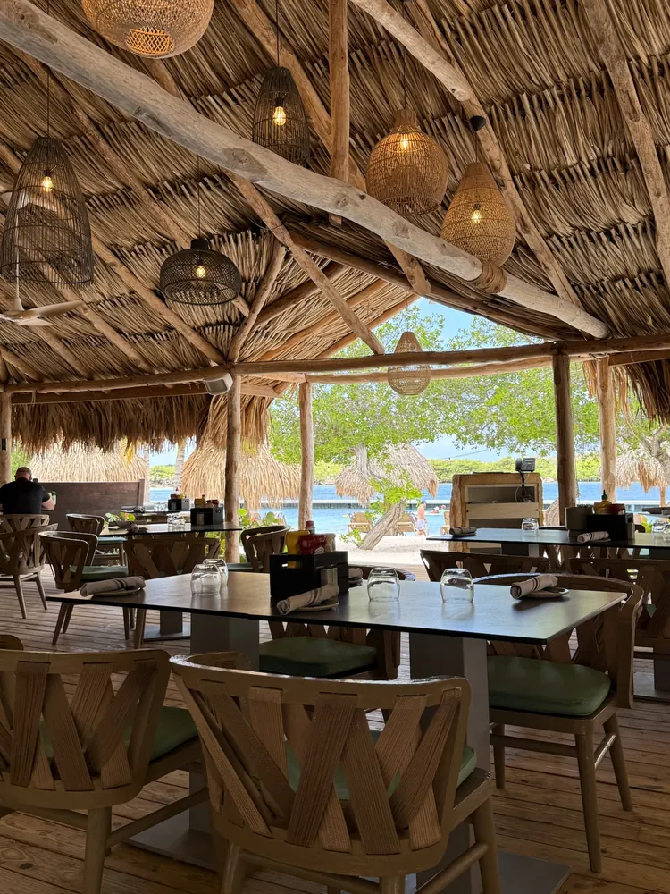 Open-air thatched-roof restaurant at Sandals Royal Curaçao