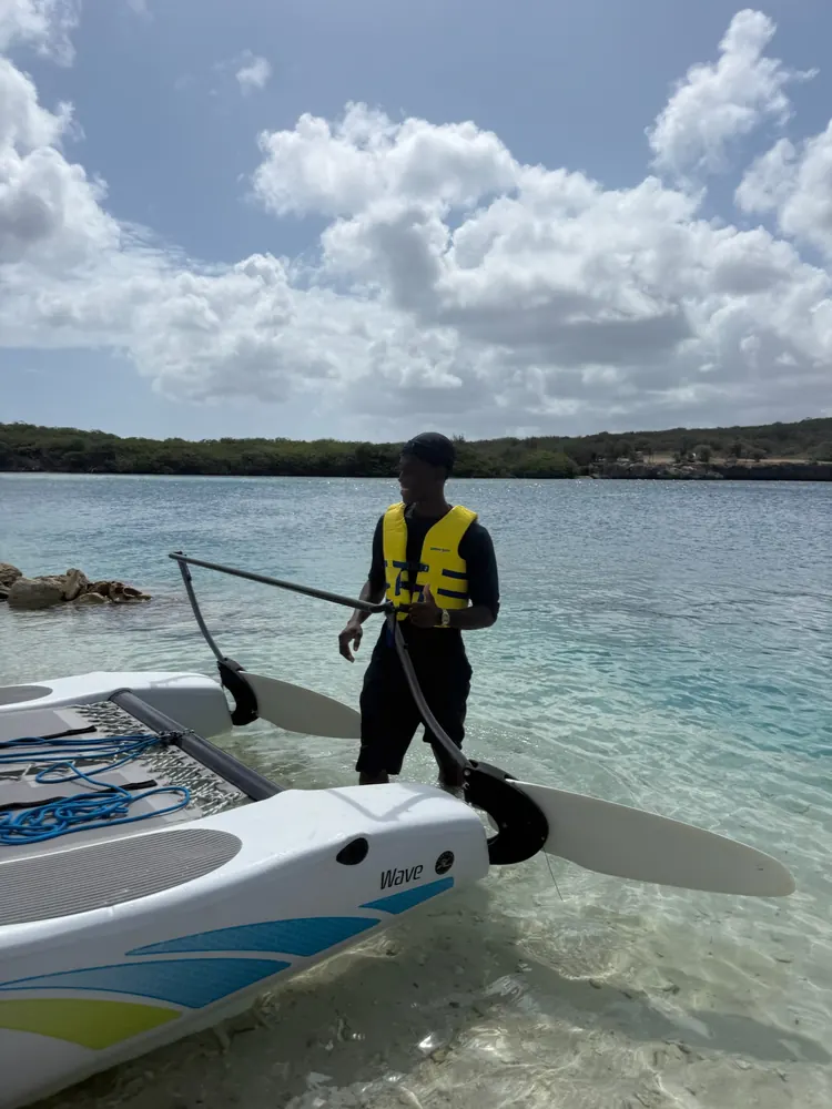 Water sports team member launching a Hobie Cat in clear water at Sandals Curaçao