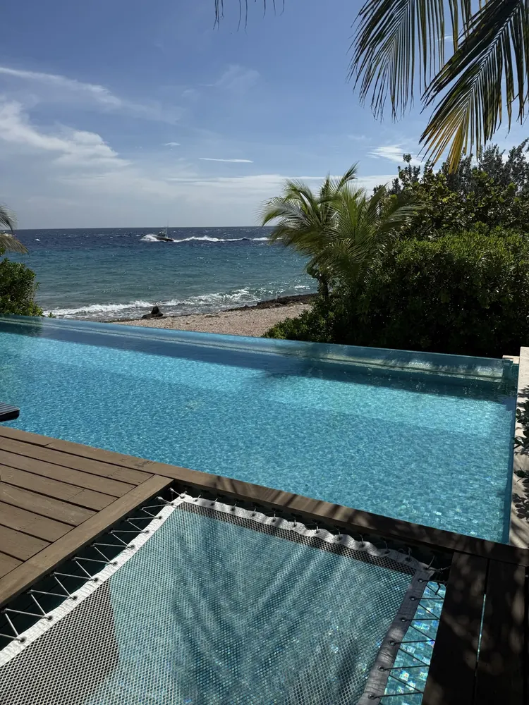 Infinity pool with a built-in net lounger overlooking the ocean at Sandals Royal Curaçao