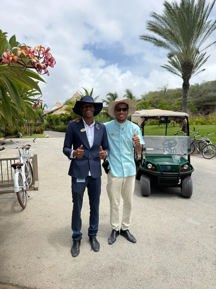Sandals Curaçao butler with a guest beside a golf cart on the resort grounds